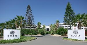 a building with palm trees in front of a road at Azia Resort & Spa in Paphos City