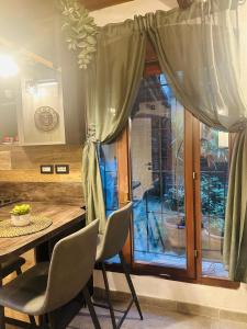 een eetkamer met een tafel en stoelen en een raam bij Veba Ferrara Antica in Ferrara