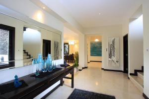 a living room with a counter with blue glass vases on it at Villa Arjuna in Tanah Lot