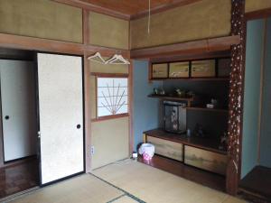 a living room with a door and a window and a room with at Guesthouse Face to Face in Fujinomiya
