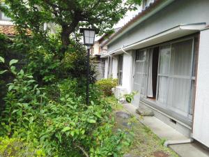 Guesthouse Face to Face في فوجينوميا: منزل به ضوء الشارع بجانب شجرة