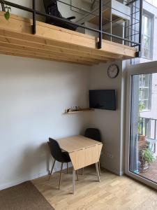 a dining room with a table and two chairs and a clock at Vilnius Cozy Loft in Vilnius
