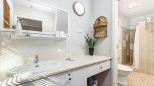 a bathroom with a sink and a toilet and a mirror at Bribie Beach House, Waterfront directly across the road - Solander Esp, Banksia Beach in Old Bribie