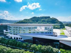 ein Bürogebäude mit einem Berg im Hintergrund in der Unterkunft Cachet Boutique Shaoxing in Dongpu