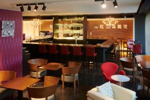 ein Restaurant mit Tischen und Stühlen und einer Bar in der Unterkunft Cross Hotel Sapporo in Sapporo