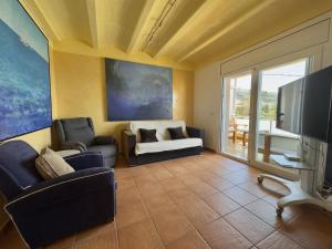 a living room with a couch and a tv at Los Sauces in Roses