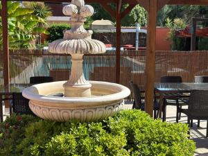 a large stone fountain sitting in a garden at Les Terrasses in Lavérune