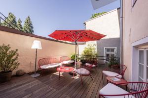 taras ze stołem, krzesłami i parasolem w obiekcie Boutiquehotel Amadeus w mieście Salzburg