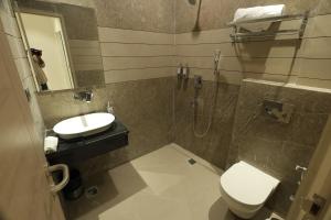a bathroom with a toilet and a sink and a shower at Hotel Dreamz in Karnal +16 photos