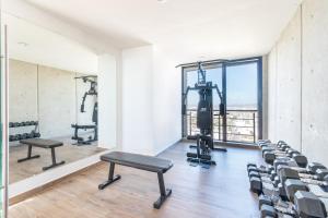 a gym with treadmills and benches in a room at Ocean View - 2 King Size with Homeoffice Space in Mazatlán