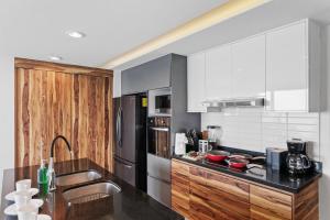 a kitchen with a black counter and a stainless steel refrigerator at Ocean View - 2 King Size with Homeoffice Space in Mazatlán