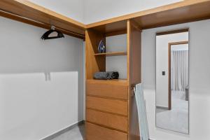 a room with a wooden cabinet and a mirror at Ocean View - 2 King Size with Homeoffice Space in Mazatlán +28 photos