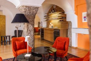 salon z pomarańczowymi krzesłami i stołem w obiekcie Boutiquehotel Amadeus w mieście Salzburg