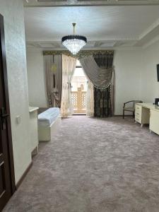 a large room with a bed and a chandelier at Ark Hotel in Bukhara