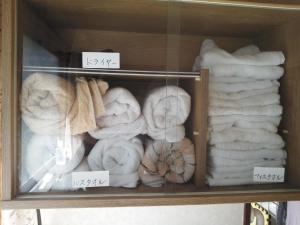 une étagère remplie de serviettes et de serviettes dans l'établissement Guesthouse Face to Face, à Fujinomiya