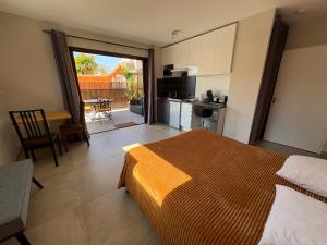 a bedroom with a bed and a kitchen with a balcony at Les Terrasses in Lavérune