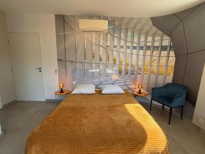 a bedroom with a large bed and a blue chair at Les Terrasses in Lavérune +11 photos
