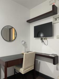 a desk with a mirror and a chair in a room at Miran Hotel in Legazpi +26 photos