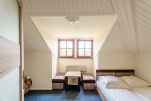 a bedroom with a table and a bed and a window at Pensjonat Pod Lwem in Niechorze