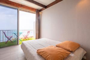 une chambre avec un lit et une grande fenêtre dans l'établissement Les Jeux de Boules 6, au Pradet