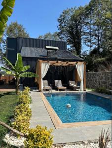 a swimming pool with two chairs and a gazebo at LexiaDeluxeSuit in Sapanca