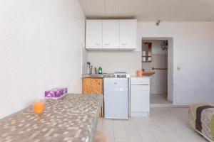 eine Küche mit einem Tisch und einem weißen Kühlschrank in der Unterkunft Porte Rouge 3 in Le Pradet + 12 Fotos