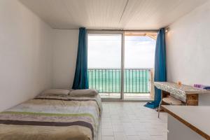 ein Schlafzimmer mit einem Bett und einem großen Fenster in der Unterkunft Porte Rouge 3 in Le Pradet