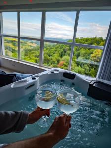 two people holding wine glasses in a bath tub at Wellness pod zvezdami, Maribor - PRIVATE in Maribor