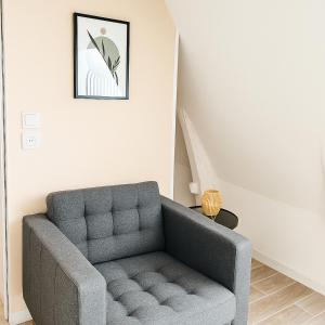 a gray couch in a living room with a staircase at Studio Cosy ambiance Tiny House in Angers