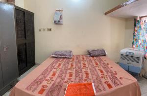 a bedroom with a bed with pillows on it at Jaykishan sadan in Varanasi
