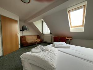 a attic room with two beds and a chair at Aparthotel Mariazellerhof in Sankt Pölten +74 photos