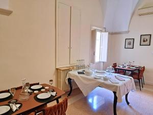 a dining room with two tables and chairs and a room with two tables at Suite Verdi suite room in Lecce