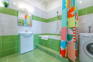 een groene en witte badkamer met een wastafel en een wasmachine bij Modern Apartment Zitna in Praag