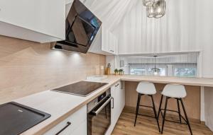 una cocina con armarios blancos, fregadero y 2 taburetes en Amazing Home In Kirchheim With Sauna, en Kirchheim