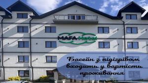 a large white building with a sign in front of it at MAFA Hotel in Bukovel