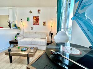 a living room with a couch and a glass table at Le Vintage, centre, parking gratuit in Pont-sur-Yonne
