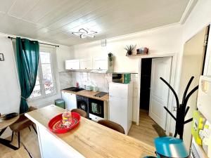 a kitchen with a wooden table and a kitchen with a counter at Le Vintage, centre, parking gratuit in Pont-sur-Yonne