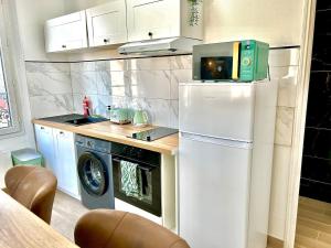 a small kitchen with a refrigerator and a microwave at Le Vintage, centre, parking gratuit in Pont-sur-Yonne +22 photos