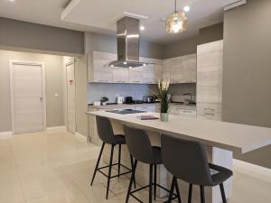 a kitchen with a large island with bar stools at Salus Holiday Apartment in Victoria +48 photos