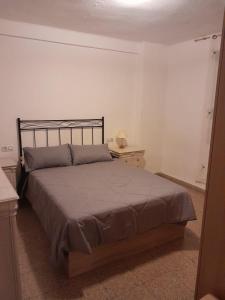 a bedroom with a bed and a table with a lamp at Alojamiento El Sevillano in Cullera