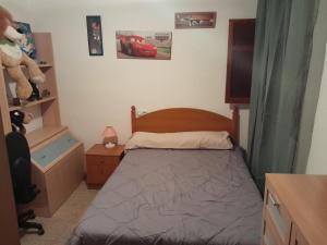 a small bedroom with a bed and a teddy bear at Alojamiento El Sevillano in Cullera