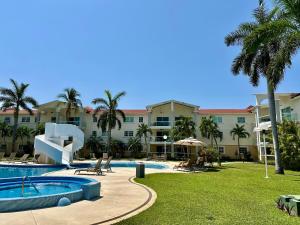 a view of a resort with a pool and palm trees at PARAISO ESCONDIDO e126 in Acapulco