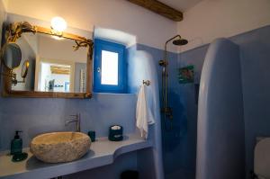 a blue bathroom with a sink and a mirror at Rodamia Traditional Cottage in Kythira