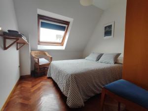 a bedroom with a bed and a window and a chair at Apartamento centro de Sada in Sada