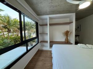 a bedroom with a white bed and a large window at Pé Na Areia, 6 Quartos, Casa Azul in Bertioga +48 photos