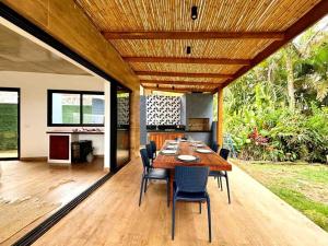 a dining room with a wooden table and chairs at Pé Na Areia, 6 Quartos, Casa Azul in Bertioga