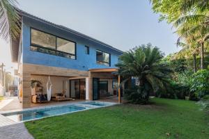 a house with a swimming pool in the yard at Pé Na Areia, 6 Quartos, Casa Azul in Bertioga