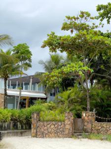 a house with a tree in front of it at Pé Na Areia, 6 Quartos, Casa Azul in Bertioga
