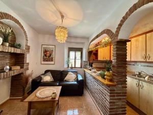a living room with a couch and a kitchen at Sunshine Home Competa in Cómpeta