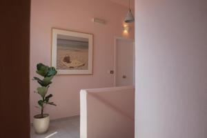 a bathroom with pink walls and a potted plant at Nina's apartment in Lixouri